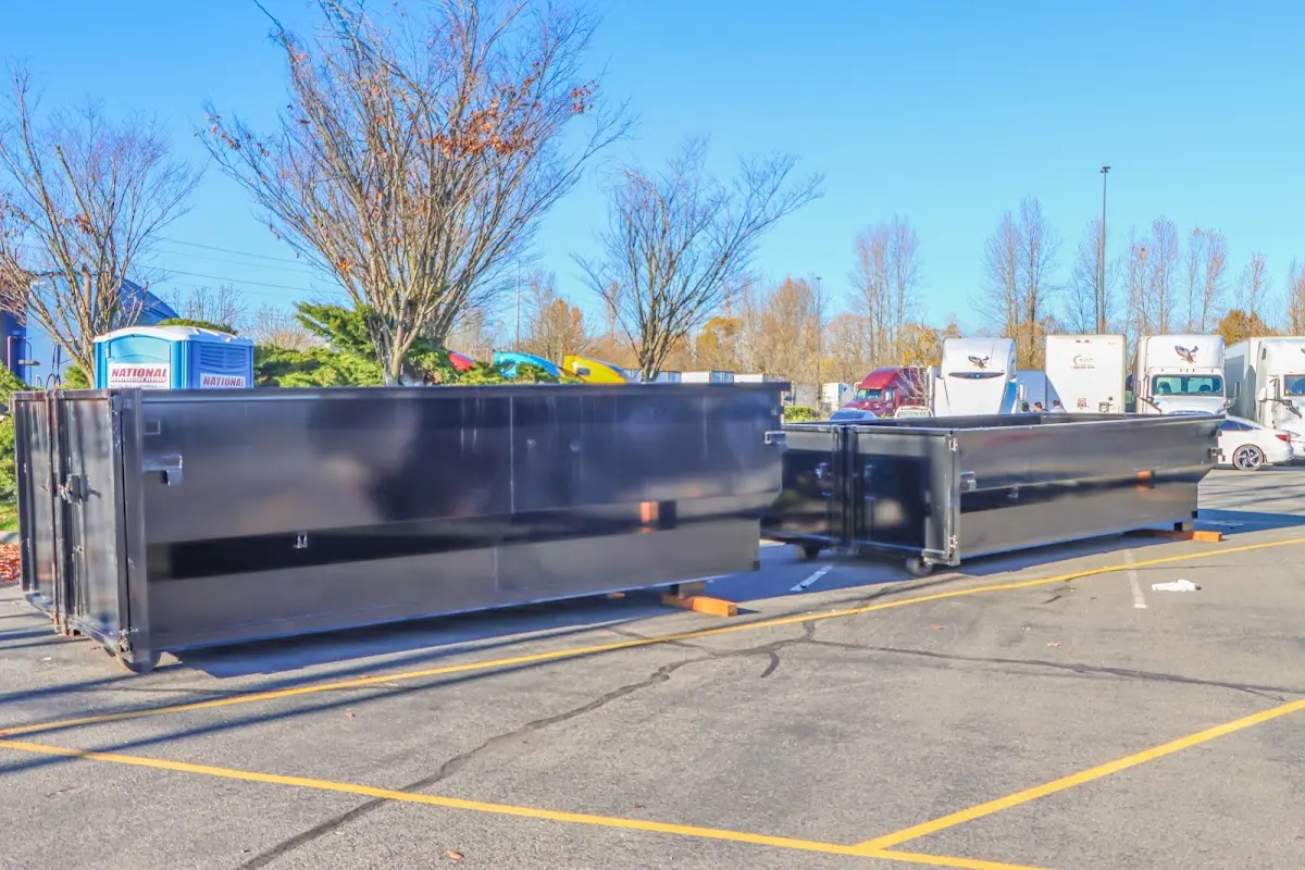 Professional dumpster rental service with roll-off container on residential driveway in University Heights